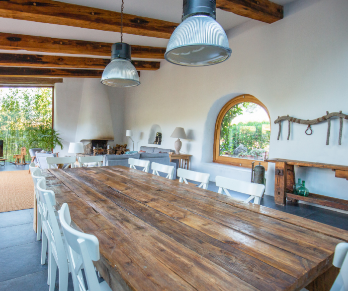 Medium toned wood farmhouse dining table in open dining room space