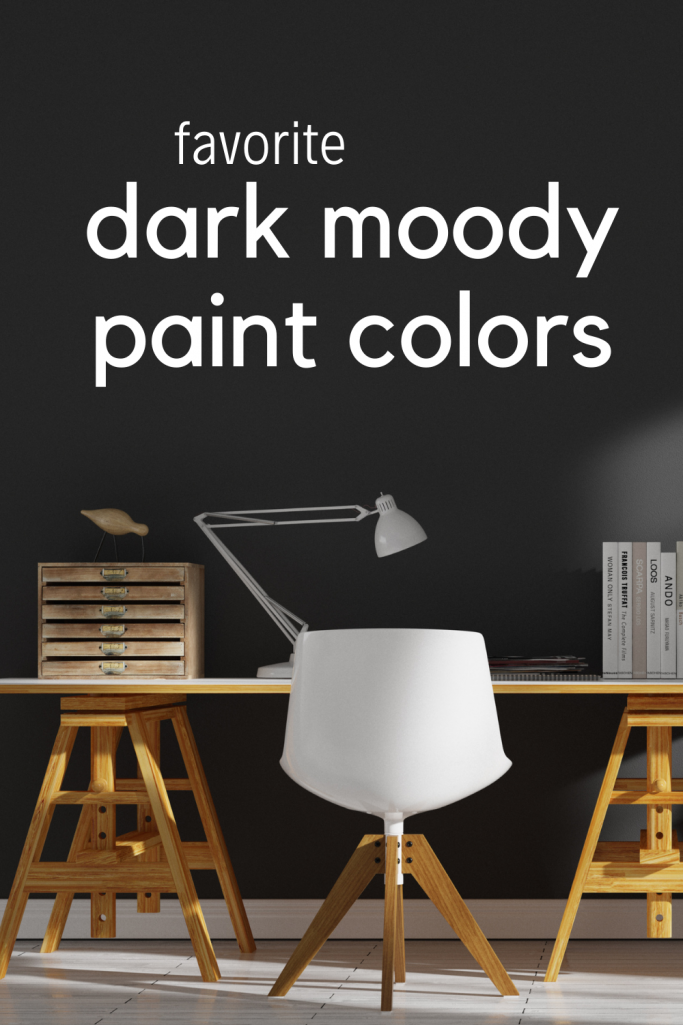 Favorite Dark Moody Paint Colors - a home office with a black accent wall, light stained wooden desk and white chair