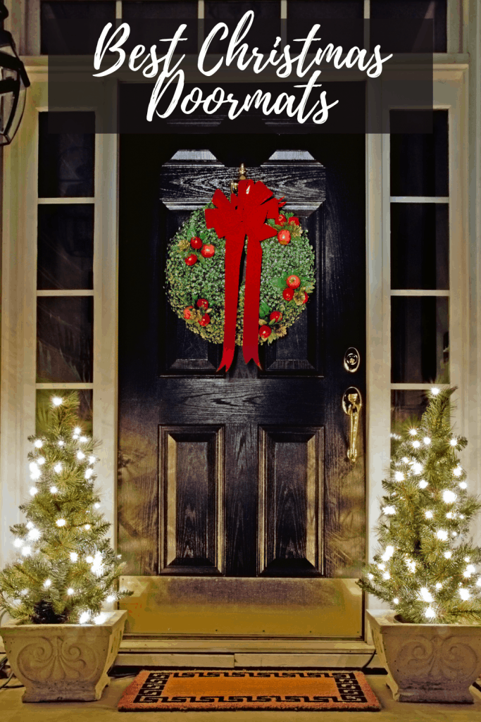 Best Christmas Doormats - A festive doormat in front of black doors with a big green wreath and red bow