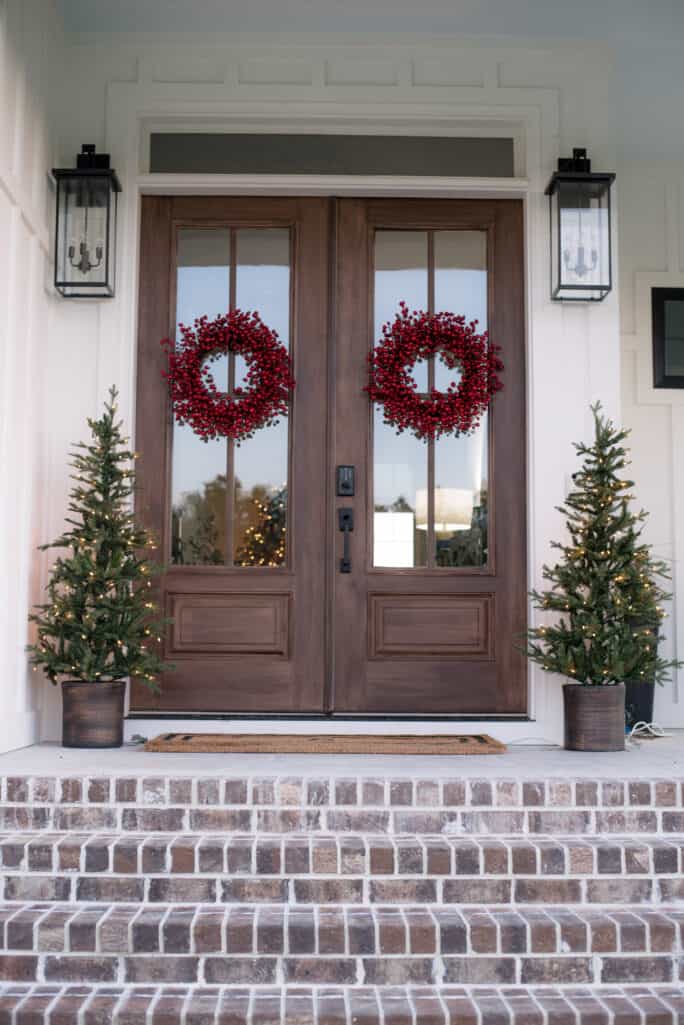 Porch Decor - Double doors with red berry wreaths flanked by 5' lighted Christmas trees
