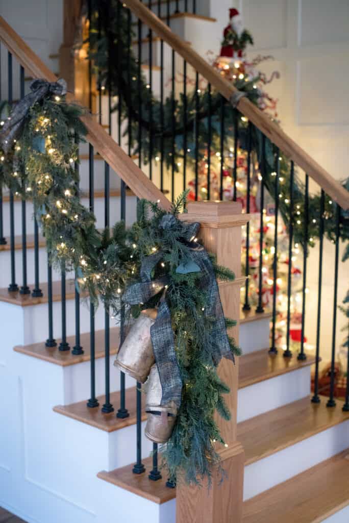 staircase with green garland and gold bells