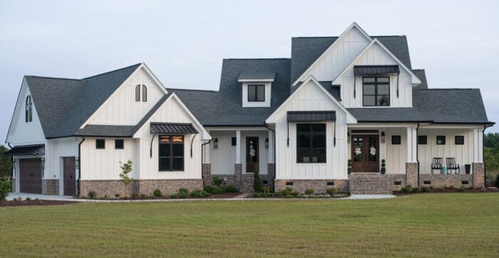 modern white farmhouse with gray awnings